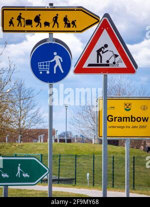 15 avril 2021, Mecklembourg-Poméranie occidentale, Grambow : les panneaux de signalisation du futur représentent un projet artistique du groupe d'artistes Reinigungsgesellschaft (Martin Keil et Henrik Mayer) dans le centre du village. Les artistes de Dresde ont mis au point un « système d'orientation pour le nouveau Grambow 2057 », qui visualise les idées et suggestions pour une vie rurale meilleure dans des pictogrammes colorés. Le contenu est le village de Grambow en l'an 2057, quand le village aura 700 ans. Douze panneaux de signalisation en tôle d'acier galvanisée traitent de questions telles que le changement climatique, le développement démographique, l'emploi, un Banque D'Images