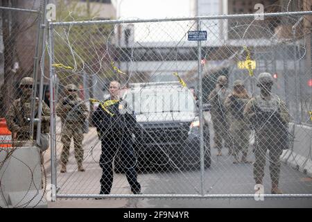 Minneapolis, Minnesota, États-Unis. 19 avril 2021. 19 avril 2021 - Minneapolis, Minnesota, États-Unis : les membres du département de police de Minneapolis et de la Garde nationale du Minnesota se tiennent derrière une clôture en fil de rasoir. Plus de 400 manifestants ont défilé dans le centre-ville de Minneapolis peu après la clôture des arguments du procès de Derek Chauvin. Chauvin, d'Oakdale (Minnesota), est jugé pour le meurtre de George Floyd alors qu'il était en service comme agent de police de Minneapolis le 25 mai 2020. Crédit : Henry Pan/ZUMA Wire/Alay Live News Banque D'Images