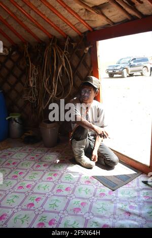 Homme à l'intérieur du gareur d'une famille de bergers en activité dans le désert de Gobi qui accueille des visites de touristes et offre un goût de l'airag, lait de jument fermenté. Banque D'Images