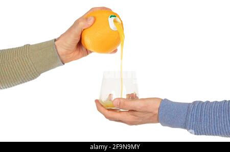Jus d'orange versé dans le verre, directement hors de l'orange Banque D'Images