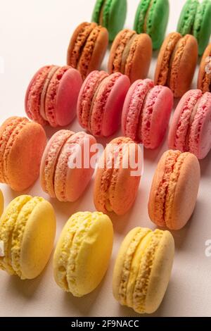 Des macarons colorés en rangée sur fond clair Banque D'Images