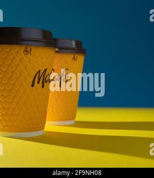 Ukraine, Kiev - 17 février 2021 : verre de café jaune de McDonald's. Verre en papier boisson McCafe. Coupe en offee sur table avec ombres. Menu dans fastfood Banque D'Images