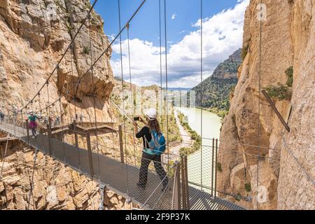 Personnes traversant le pont suspendu à Royal Trail (El Caminito del Rey) dans la gorge Chorro, province de Malaga. Banque D'Images