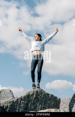 Les bras de femme levés jusqu'au ciel bleu, célébrant la liberté. Émotions humaines positives, succès, concept de tranquillité d'esprit. Banque D'Images