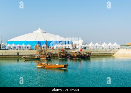 Un groupe de dhows, des bateaux traditionnels de Bahreïn, s'ancre devant une tente blanche Banque D'Images