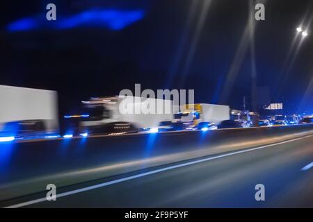 les camions routiers se déplacent sur l'autoroute de nuit Banque D'Images