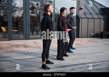 Exercice de détente au qigong en groupe de trois Banque D'Images