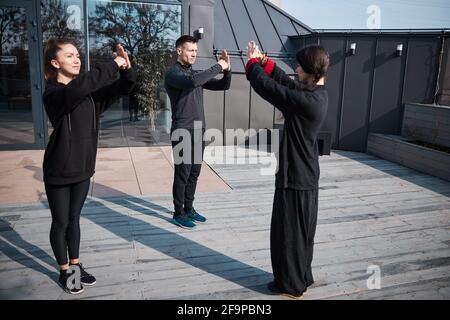 Un instructeur de kung fu termine la leçon par un geste de salutation formel Banque D'Images