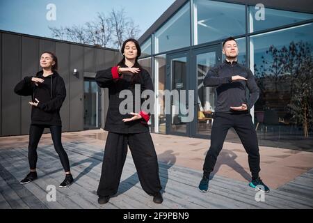 Les étudiants de kung fu sur la terrasse tenant des palmiers parallèles Banque D'Images