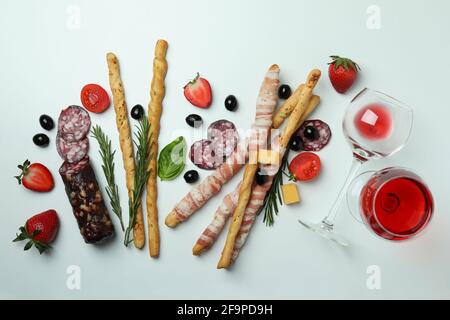 Bâtonnets de Grissini au bacon, en-cas et vin sur fond blanc Banque D'Images
