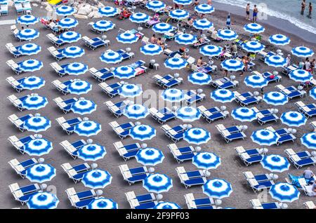 vue aérienne des parasols bleus et blancs situés sur une plage en italie. Banque D'Images