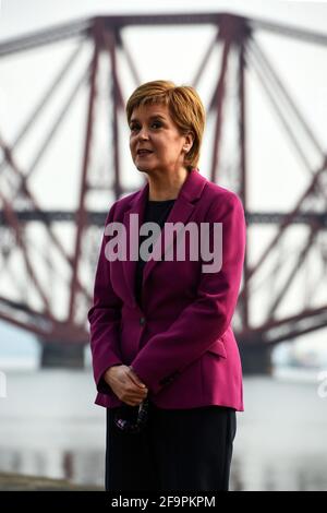 La première ministre écossaise Nicola Sturgeon, chef du Parti national écossais (SNP), à côté du Firth of Forth et du Forth Bridge pendant qu'elle fait campagne dans le sud du Queensferry lors de la campagne pour les élections parlementaires écossaises. Date de la photo: Mardi 20 avril 2021. Banque D'Images