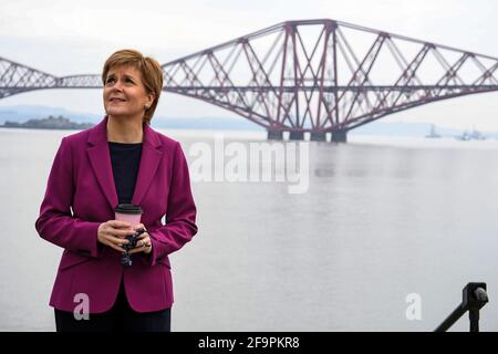 La première ministre écossaise Nicola Sturgeon, chef du Parti national écossais (SNP), à côté du Firth of Forth et du Forth Bridge pendant qu'elle fait campagne dans le sud du Queensferry lors de la campagne pour les élections parlementaires écossaises. Date de la photo: Mardi 20 avril 2021. Banque D'Images