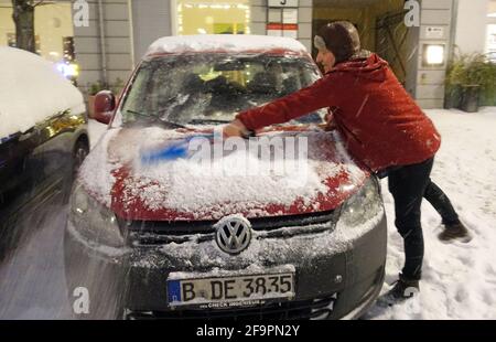 08.02.2021, Berlin, , Allemagne - Homme balayant la neige fraîchement tombée de sa voiture garée dans la soirée. 00S210208D554CAROEX.JPG [VERSION DU MODÈLE : NON, PROPE Banque D'Images