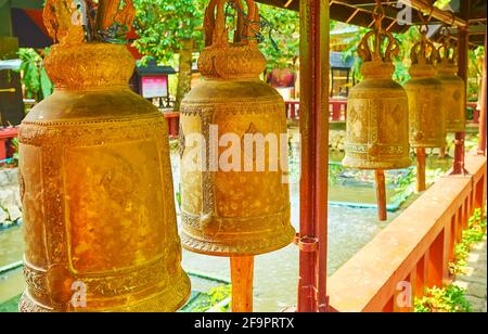 Les cloches dorées pittoresques de l'étang du temple Wat Phra Kaew, Chiang Rai, Thaïlande Banque D'Images