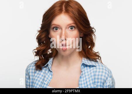 redhead femme en chemise à carreaux bleu faisant le visage de poisson avec lèvres isolées sur blanc Banque D'Images