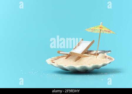 Concept de plage tropicale fait de doit avec sable, chaise de pont et parasol. Concept de vacances d'été créatif Banque D'Images