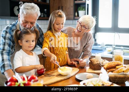 Grandchildrens avec plaisir les filles le petit-déjeuner avec ses grands-parents Banque D'Images