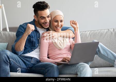 Un couple arabe heureux avec un ordinateur portable qui se relève Banque D'Images