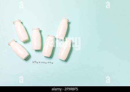 Petits flacons avec probiotiques et prébiotiques boisson laitière sur fond bleu. Production avec des additifs biologiquement actifs. Fermentation et régime guérir Banque D'Images