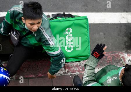 Bangkok, Thaïlande. 20 avril 2021. Un motard de Grab vu faire la livraison.pendant la pandémie de Covid-19 le réseau de service de livraison de nourriture à domicile de Grab s'est élargi avec des milliers d'anciens motards de taxi à travers le pays changeant au service de livraison de Grab via l'application en ligne de Grab Les clients peuvent commander leurs plats thaïlandais et occidentaux préférés en ligne dans une variété de restaurants locaux et populaires à Bangkok. (Photo de Paul Lakatos/SOPA Images/Sipa USA) crédit: SIPA USA/Alay Live News Banque D'Images