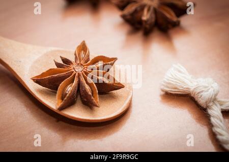Mettre en étoile les graines d'anis et les fruits sur une cuillère en bois Banque D'Images