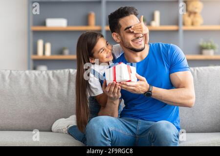 Fille aimante célébrant la journée du père, saluant papa excité avec boîte Banque D'Images