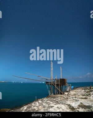 Les anciennes machines de pêche de Trabucco dans la baie de San Lorenzo la nuit, Vieste, province de Foggia, Gargano, Apulia, Italie Banque D'Images