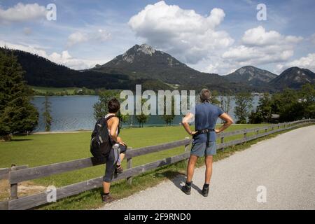 Vue arrière d'un couple adulte de taille moyenne se trouvant près du lac Fuschl à Fuschl,Salzbourg,Salzkammergut,Autriche,Europe. Banque D'Images