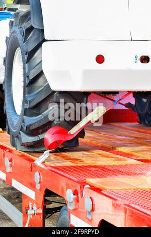 Fixation du véhicule à l'aide d'une courroie sur la plate-forme de transport. Image verticale, espace de copie. Banque D'Images