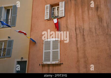 Façade de maison de style provençal avec un mur en stuc ocre à deux tons et des volets en bois à Saint-Tropez, Côte d'Azur. Banque D'Images