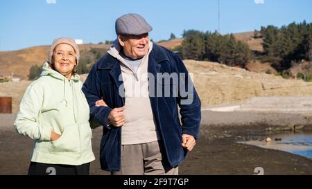 Couple de personnes âgées, couple de personnes âgées marchant sur la plage au Chili, Bucalemu. Banque D'Images