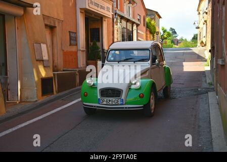 Voiture Citroën 2CV ancienne dans les rues de Roussillon avec vue sur les maisons provençales typiques dans le Vaucluse Provence, France. Banque D'Images