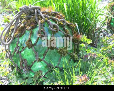 Art et créativité dans le jardin du Bedfordshire de Kathy Brown lors d'une journée portes ouvertes en avril 2021 ; une boule de verre recouverte de corde et de mousse. Banque D'Images