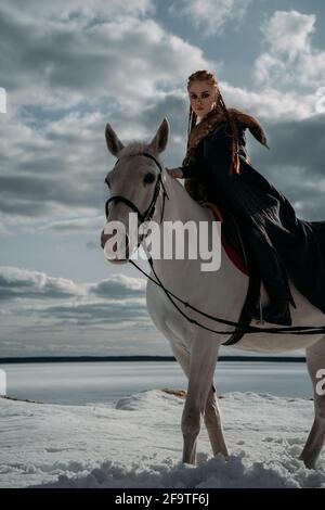 Une jeune femme viking aux poils rouges fait un cheval.Lumière spectaculaire.Jeu de rôle Banque D'Images