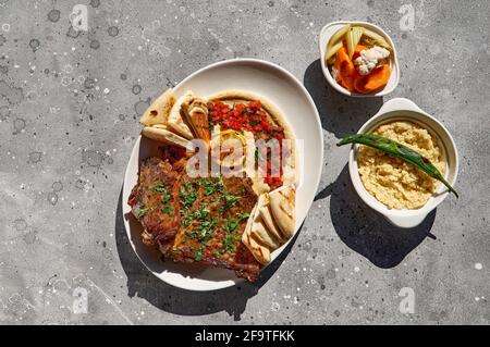 Délicieux carré d'agneau à la sauce hummus, cuisine arabe traditionnelle, turque et israélienne. Agneau rôti, vue de dessus. Banque D'Images