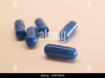 Capsules bleues sur fond pêche avec espace pour le texte. Image de médecine. Soins de santé. Banque D'Images