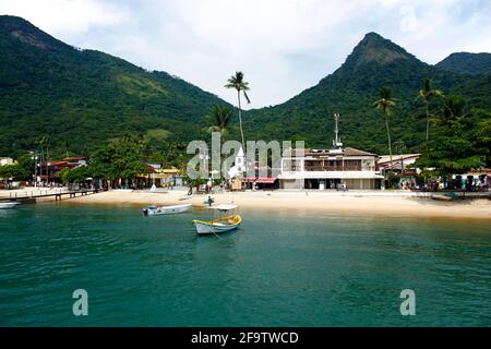 VILA DO ABRAÃO, ILHA GRANDE, RIO DE JANEIRO, BRÉSIL - 10 AVRIL 2011 : vue panoramique du village depuis un bateau. Derrière elle, les montagnes et la jungle. Banque D'Images