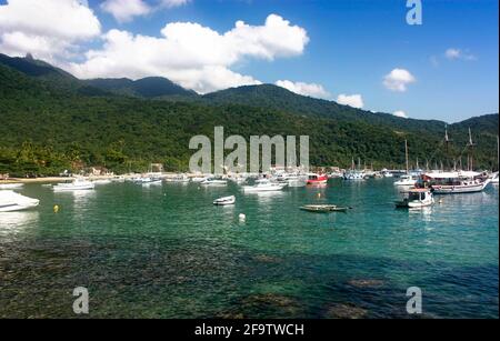 VILA DO ABRAÃO, ILHA GRANDE, RIO DE JANEIRO, BRÉSIL - 10 AVRIL 2011 : vue panoramique du village depuis un bateau. Derrière elle, les montagnes et la jungle. Banque D'Images