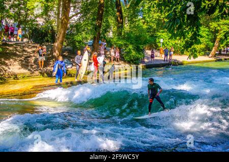 MUNICH, ALLEMAGNE, 20 AOÛT 2015: Un groupe de surfeurs pratique leur compétence sur une vague artificielle située sur une petite chaîne dans le centre de munich Banque D'Images