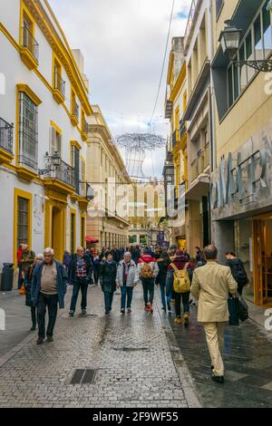 SÉVILLE, ESPAGNE, 7 JANVIER 2016: Les gens sont en route à travers une rue étroite située dans le centre de la ville espagnole séville Banque D'Images