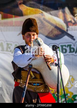 ROZHEN, BULGARIE, 18 JUILLET 2015 : un jeune joueur de cornemuse joue son instrument sur une scène du célèbre festival folklorique de rozhen en bulgarie. Banque D'Images