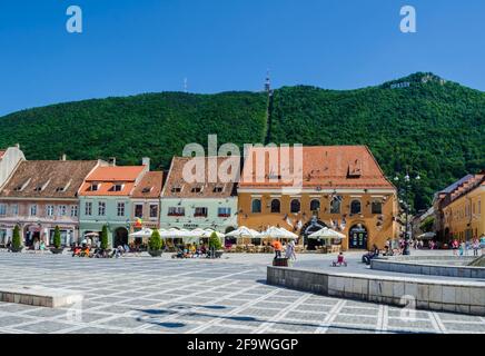 BRASOV, ROUMANIE, 6 JUILLET 2015: Council Square est le centre historique de la ville, les gens à pied et assis à des terrasses extérieures et des restaurants. Banque D'Images