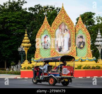 Bangkok, Thaïlande. 19 avril 2021. Un tuk tuk passe devant des portraits de la famille royale thaïlandaise dans le quartier de Dusit. Le taxi Tuk Tuk Tuk classique de renommée internationale de Thaïlande. Le taxi à trois roues est un mode populaire de transport local sans compteur pour les habitants et les touristes, le tarif est négocié en fonction de la distance. Le pousse-pousse motorisé thaïlandais est un symbole de la nation. Crédit : SOPA Images Limited/Alamy Live News Banque D'Images