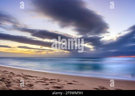 Lever de soleil couvert nuageux au-dessus d'un océan Indien rugueux depuis un point de vue sur une plage à Port Shepstone, Kwa-Zulu Natal, Afrique du Sud Banque D'Images