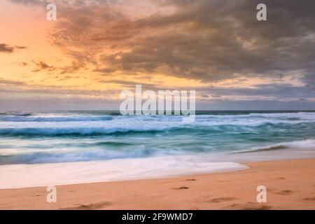 Lever de soleil couvert nuageux au-dessus d'un océan Indien rugueux depuis un point de vue sur une plage à Port Shepstone, Kwa-Zulu Natal, Afrique du Sud Banque D'Images