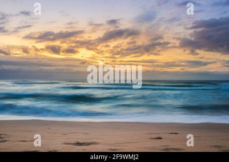 Lever de soleil couvert nuageux au-dessus d'un océan Indien rugueux depuis un point de vue sur une plage à Port Shepstone, Kwa-Zulu Natal, Afrique du Sud Banque D'Images