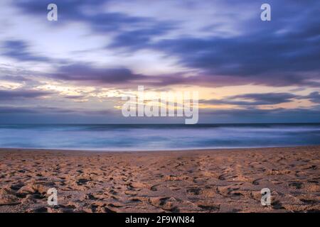 Lever de soleil couvert nuageux au-dessus d'un océan Indien rugueux depuis un point de vue sur une plage à Port Shepstone, Kwa-Zulu Natal, Afrique du Sud Banque D'Images