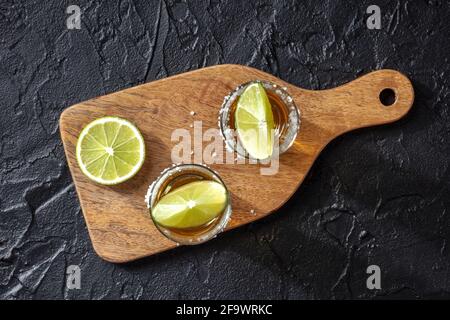 Doses de Tequila avec bords salés et tranches de lime, prises par le haut Banque D'Images