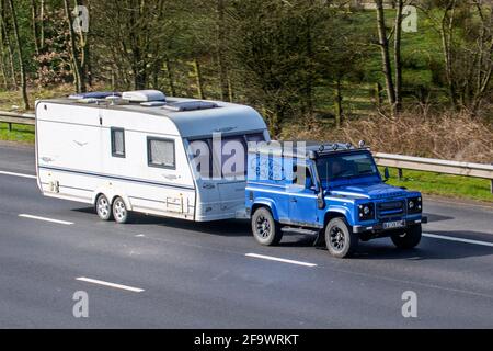 2001 bleu Land Rover Defender ; remorquage caravane laser 600/4 véhicules en mouvement, voitures, véhicule roulant sur les routes britanniques, moteurs, loisir automobile sur le réseau routier de l'autoroute M6 en anglais Banque D'Images